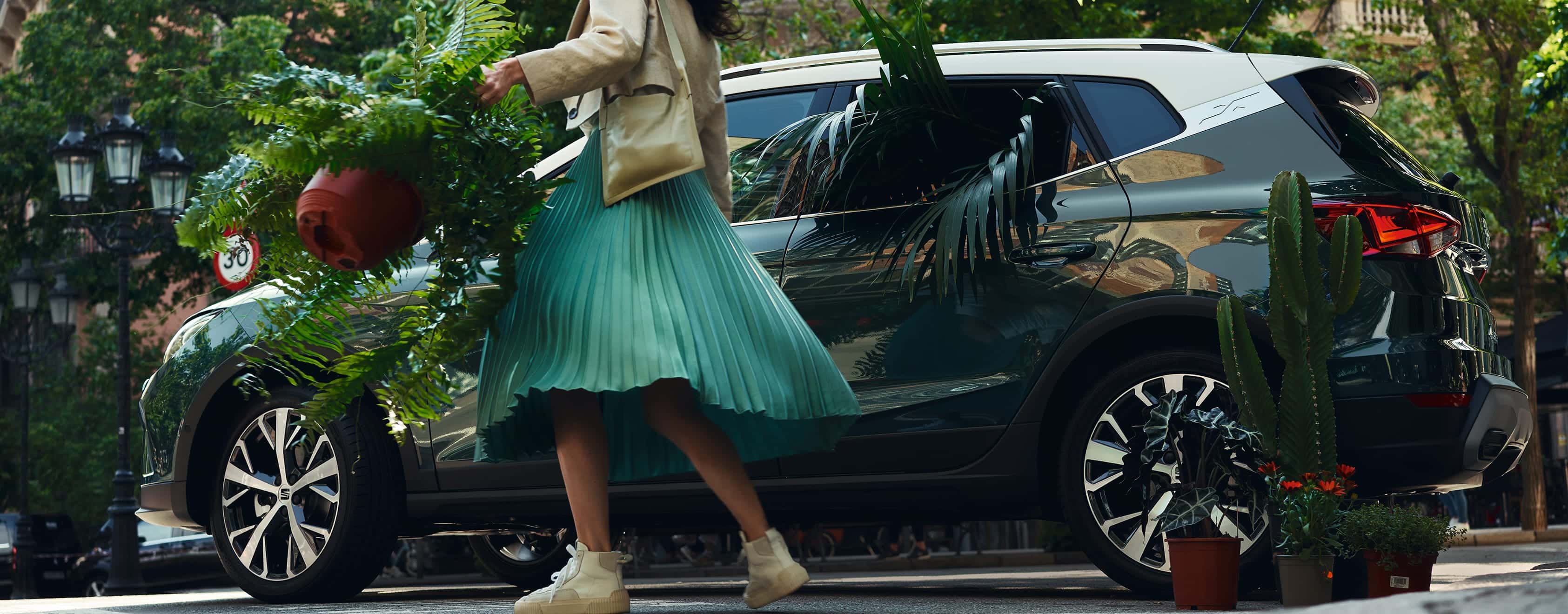 Femme avec une ouverture de plante SEAT Arona couleur camouflage foncé porte