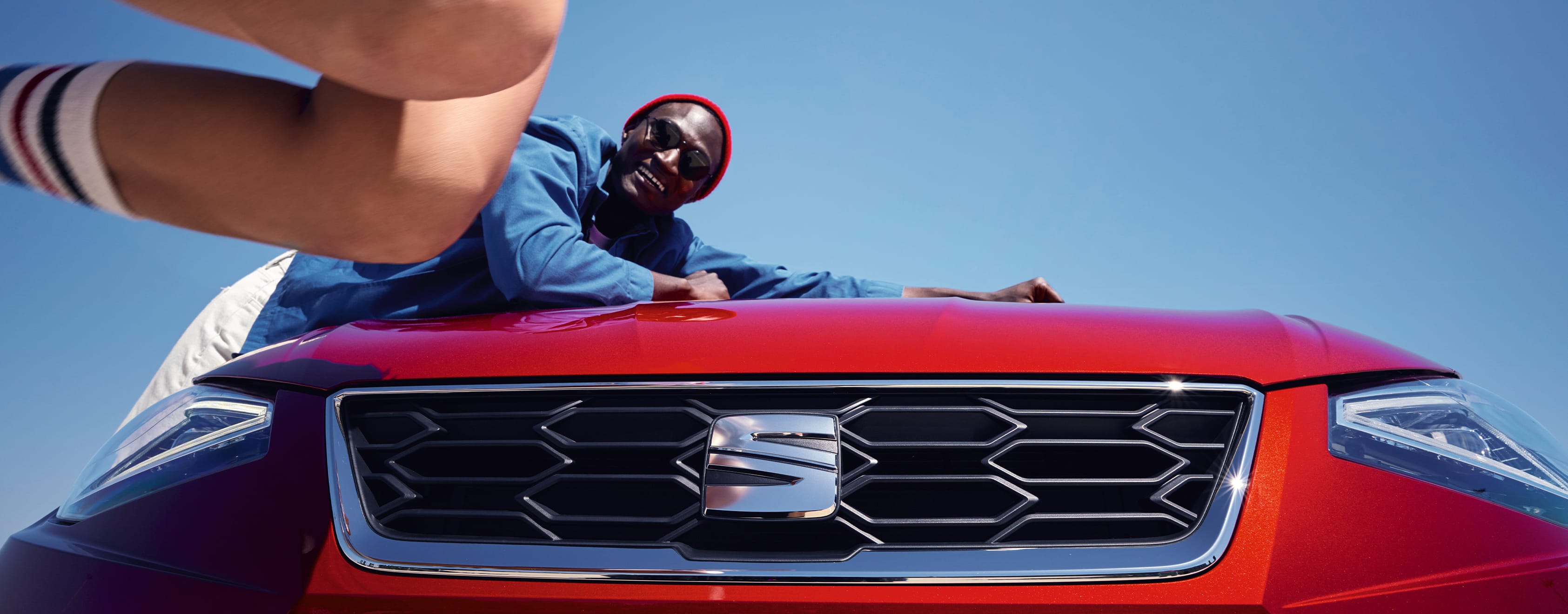 Homme penché sur SEAT Ibiza’s bonnet couleur rouge