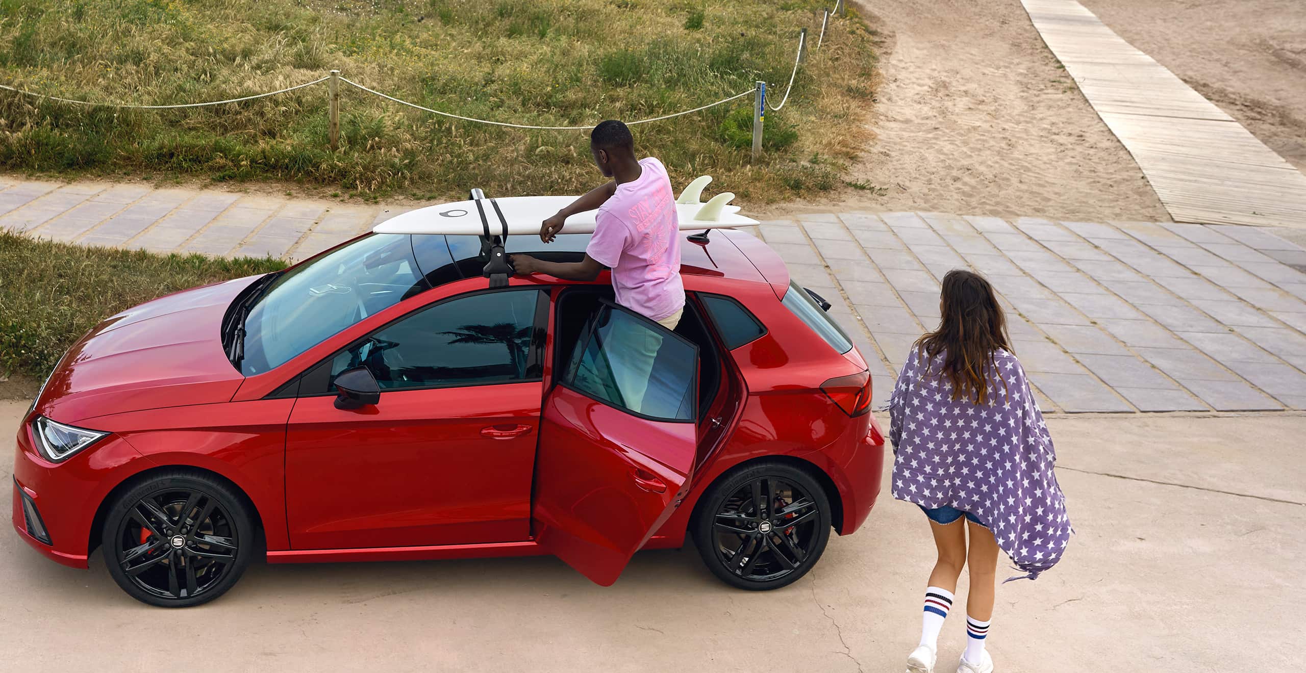 Homme installant un support de surf sur le SEAT Ibiza désir couleur rouge