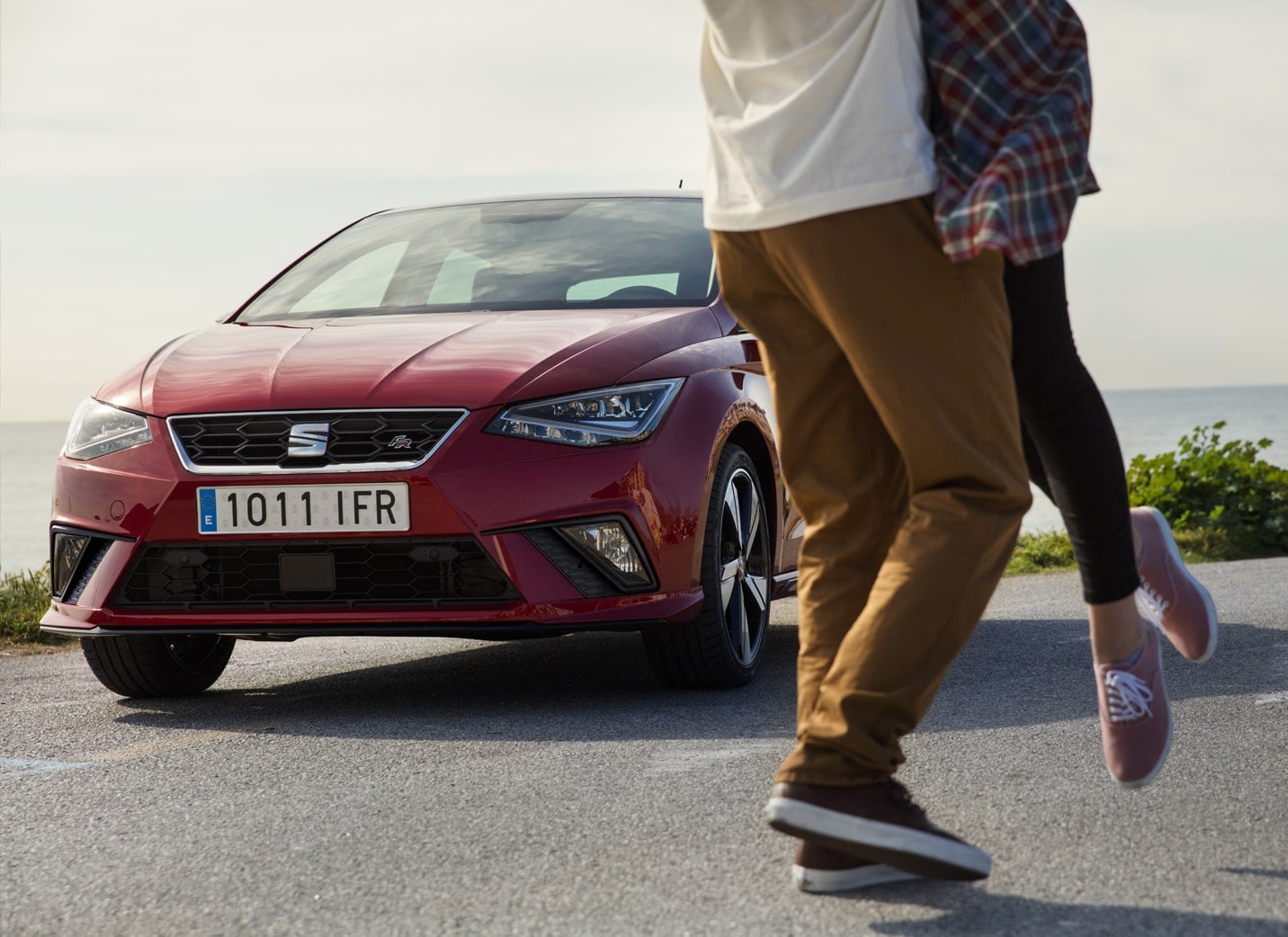 SEAT new car services and maintenance – Man and woman embracing leaning against a SEAT Leon 5D