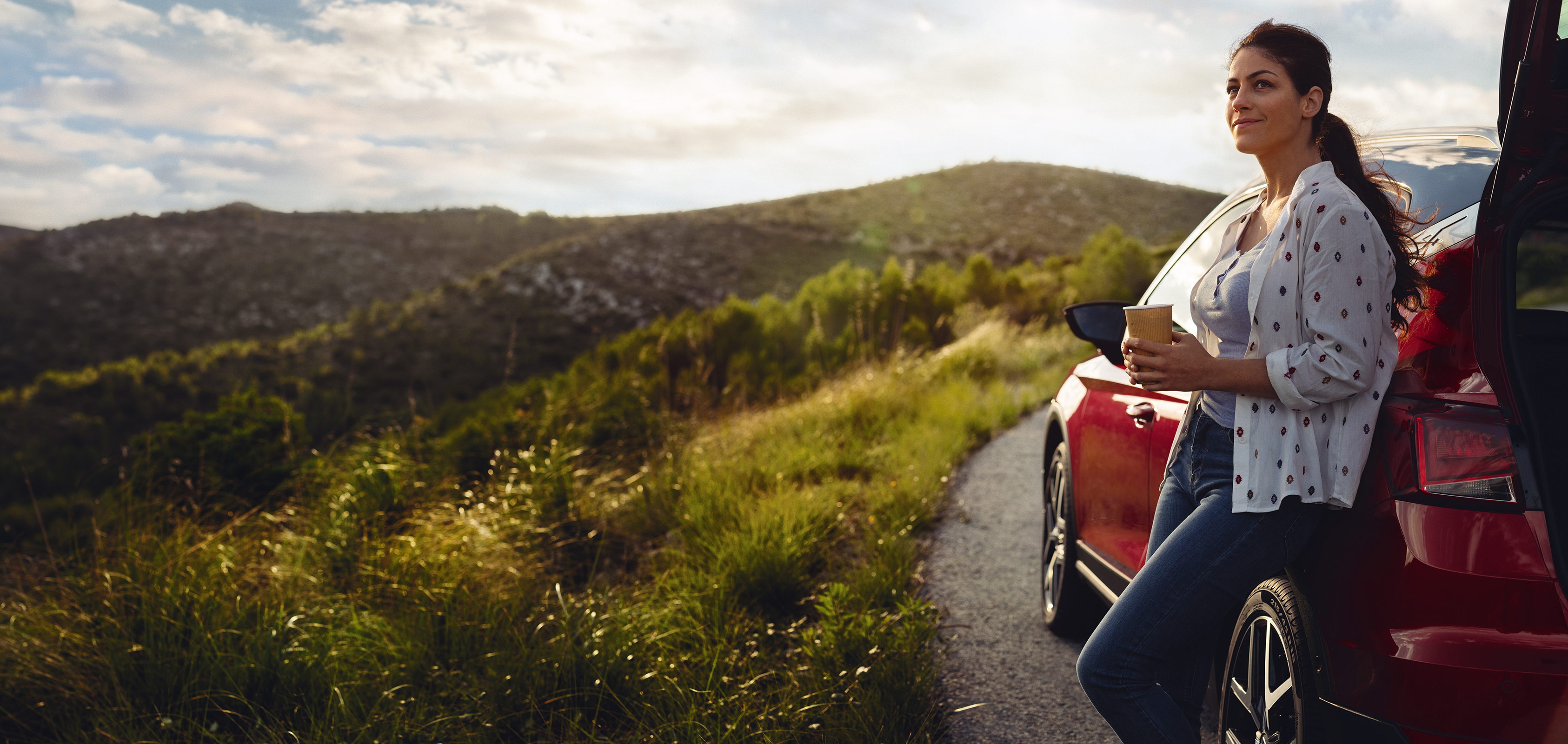 SEAT new car services – Wide shot of woman stepping out of a car hair blowing