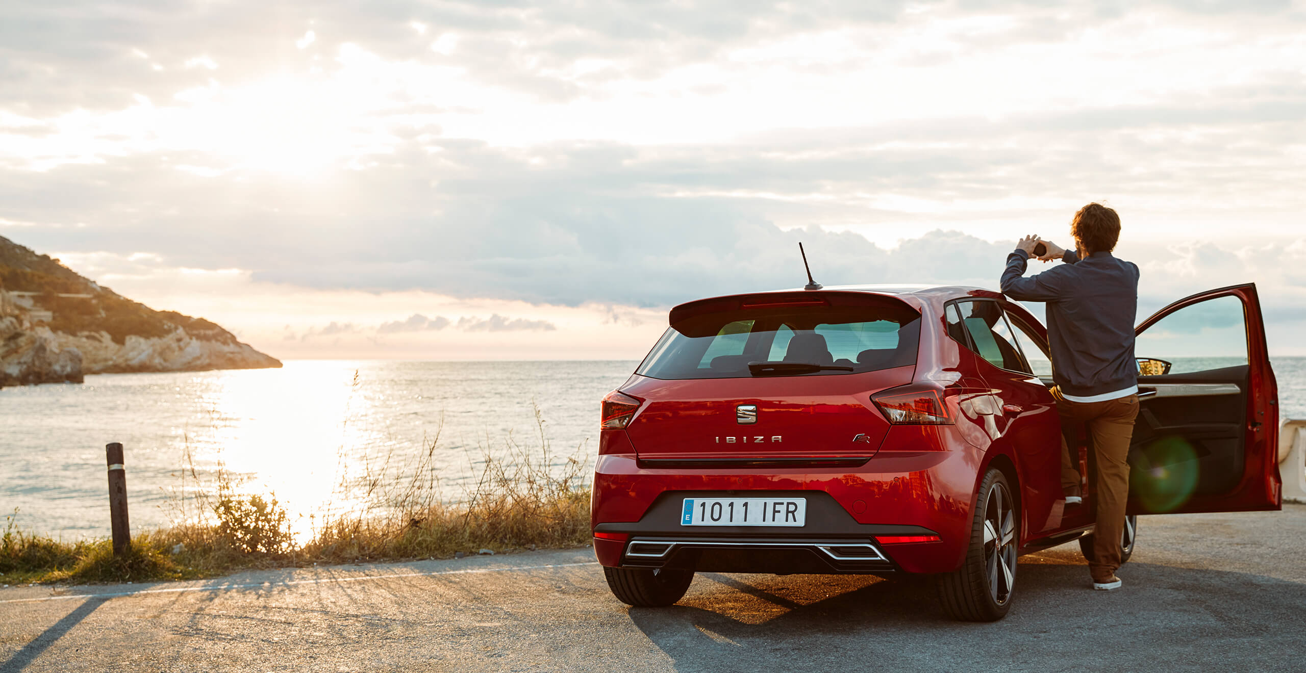 SEAT new car services and My SEAT App – SEAT Ibiza city car hatchback overlooking the sea with a man taking a photograph
